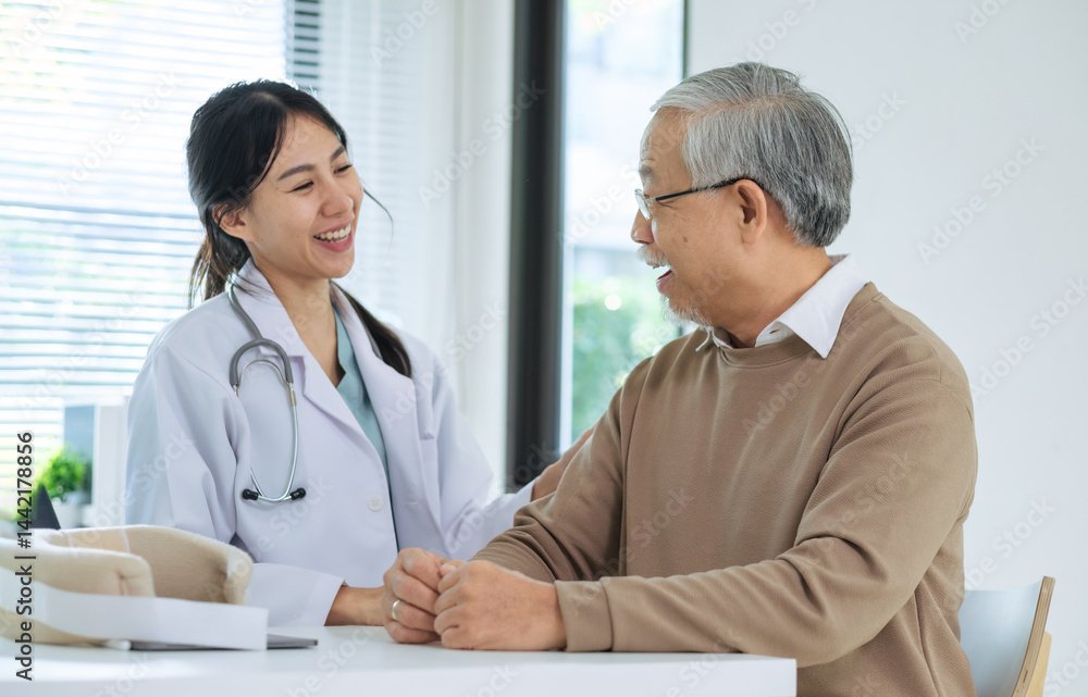 Doctor happily informs senior patient about full recovery during follow-up checkup in hospital setting